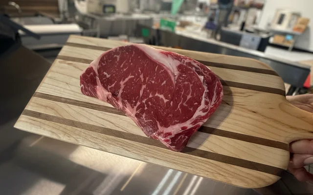 Hand-cut beef steak on a butcher's board at Grinders Meat Market